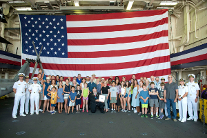 170804-N-GG858-221 SEATTLE (August 4, 2017) Members from the Rotary Club of Seattle take a group picture in the hangar bay of San Antonio-class amphibious transport dock ship USS Anchorage (LPD 23) during the 68th Annual Seafair Fleet Week in Seattle. Seafair Fleet Week is an annual celebration of the sea services wherein Sailors, Marines and Coast Guard members from visiting U.S. Navy and Coast Guard ships and ships from Canada make the city a port of call. (U.S. Navy photo by Mass Communication Specialist 2nd Class Matthew Dickinson/RELEASED)